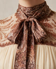 Cream Mini Ruffled Pleated Dress, close-up of brown and reddish brown accents, tie neck and gathered yoke, by Floravincie